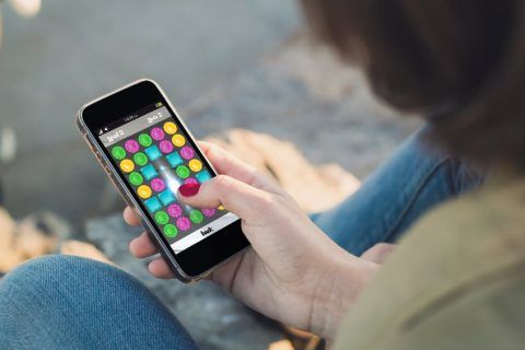 Person spielt Mobile Game auf Smartphone zur Darstellung von Gaming-Apps im Kontext von Online-Marketingstrategien.